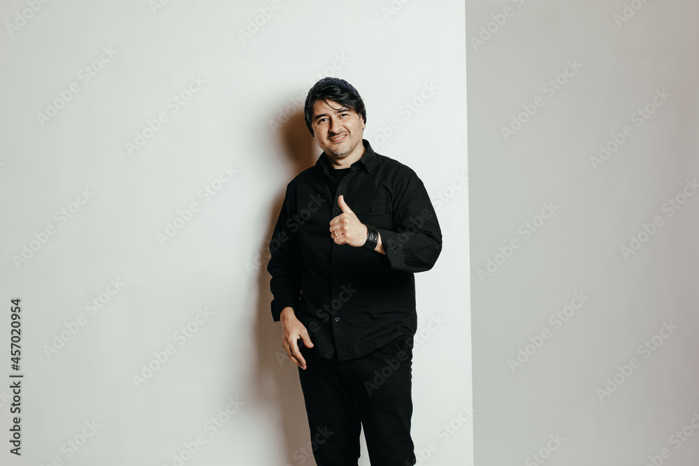 Hombre vestido de negro, roquero, con gorro y actitud positiva Hombre vestido de negro, roquero, con gorro y actitud positiva