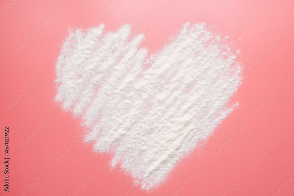 Collagen powder on pink background. Heart shaped.