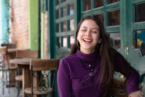 Teen with acen smiling confidently in beautiful latina street. Concept of awkward years. photo