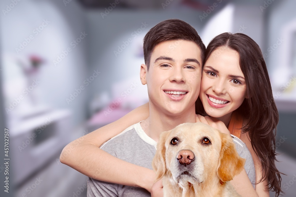 Love And Care Concept. Portrait of cheerful couple patting their dog Love And Care Concept. Portrait of cheerful couple patting their dog