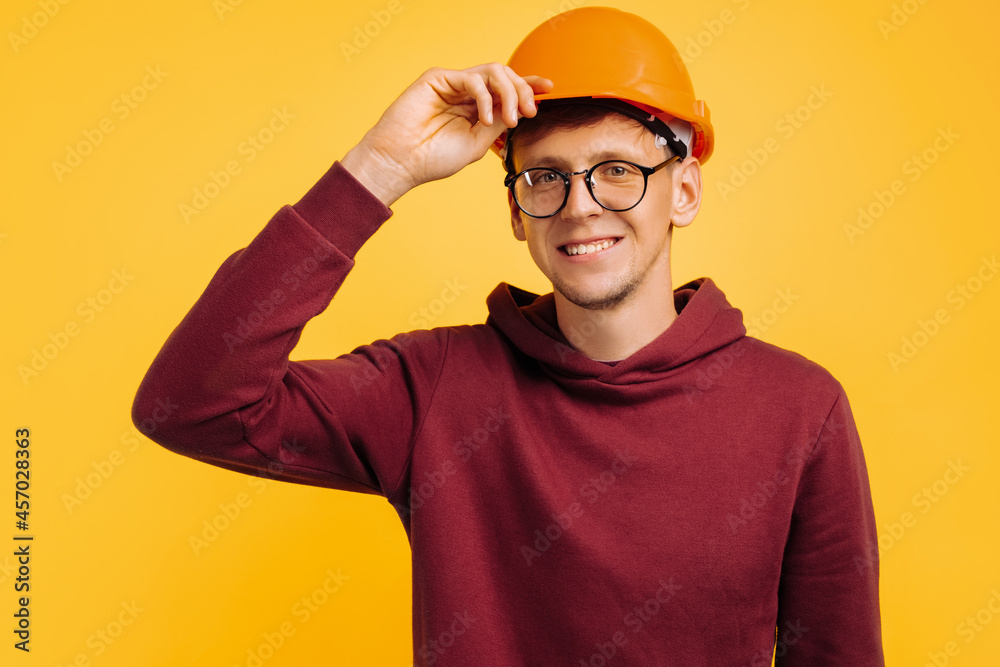 handsome man in construction helmet and glasses, young student builder, choice of profession for student