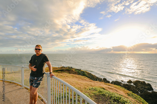 Man enjoying sunrise view from Lambert's Beach lookout in Mackay, Queensland Australia photo