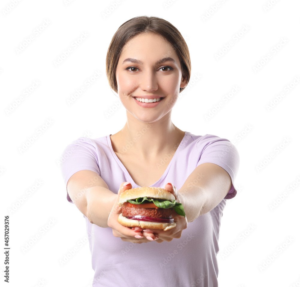 Beautiful young woman with tasty vegan burger on white background