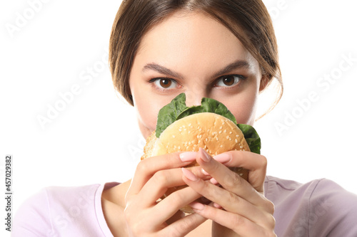 Beautiful young woman with tasty vegan burger on white background