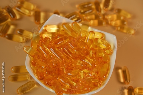 Fish Oil Gelantine Capsules in a ceramic bowl on a beige background .omega fatty acids Gelantine Capsule.Omega three acids.  photo