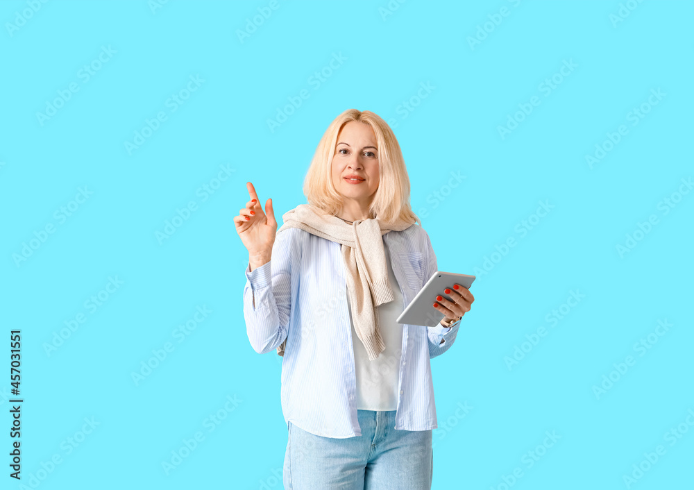 Portrait of mature woman with tablet computer on color background Portrait of mature woman with tablet computer on color background