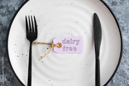 dairy-free product tag on top of dining plate with fork and knife, healthy nutrition and ethical choices