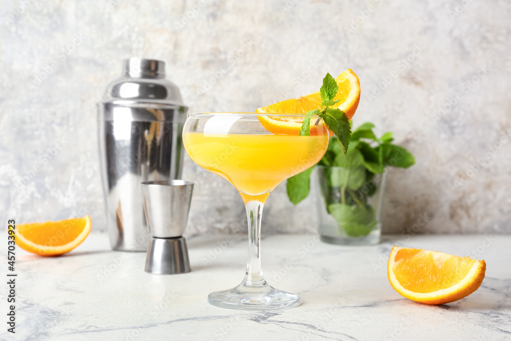Fototapeta premium Glass of orange margarita cocktail on light background