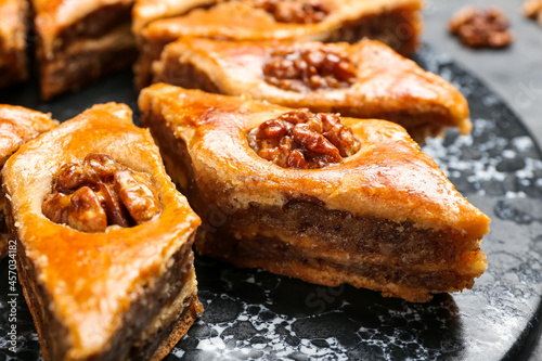 Board with tasty baklava on table, closeup