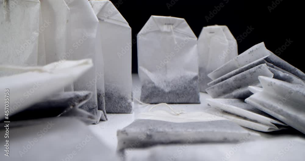 Super close-up set of tea bags on a white table on a black background. Making morning tea. Macro shooting for tea clip is suitable for culinary and culinary projects. Super close-up set of tea bags on a white table on a black background. Making morning tea. Macro shooting for tea clip is suitable for culinary and culinary projects.