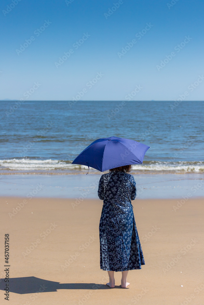 夏の海のビーチで散歩している女性の姿