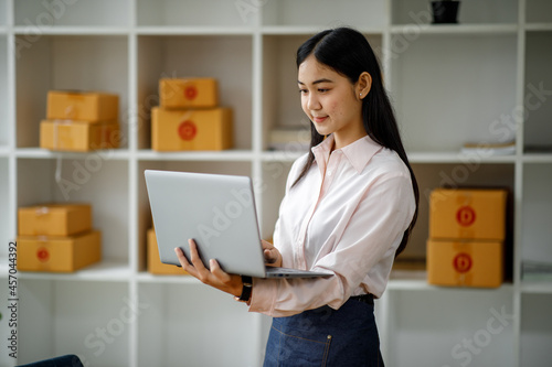 Starting Small business entrepreneur SME freelance,Portrait young woman working at home office, BOX,smartphone,laptop, online, marketing, packaging, delivery, b2b,SME, e-commerce concept
