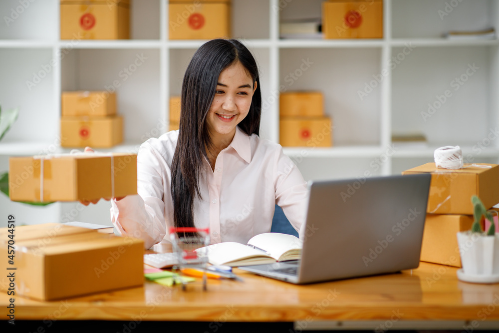 Starting Small business entrepreneur SME freelance,Portrait young woman working at home office, BOX,smartphone,laptop, online, marketing, packaging, delivery, b2b,SME, e-commerce concept Starting Small business entrepreneur SME freelance,Portrait young woman working at home office, BOX,smartphone,laptop, online, marketing, packaging, delivery, b2b,SME, e-commerce concept