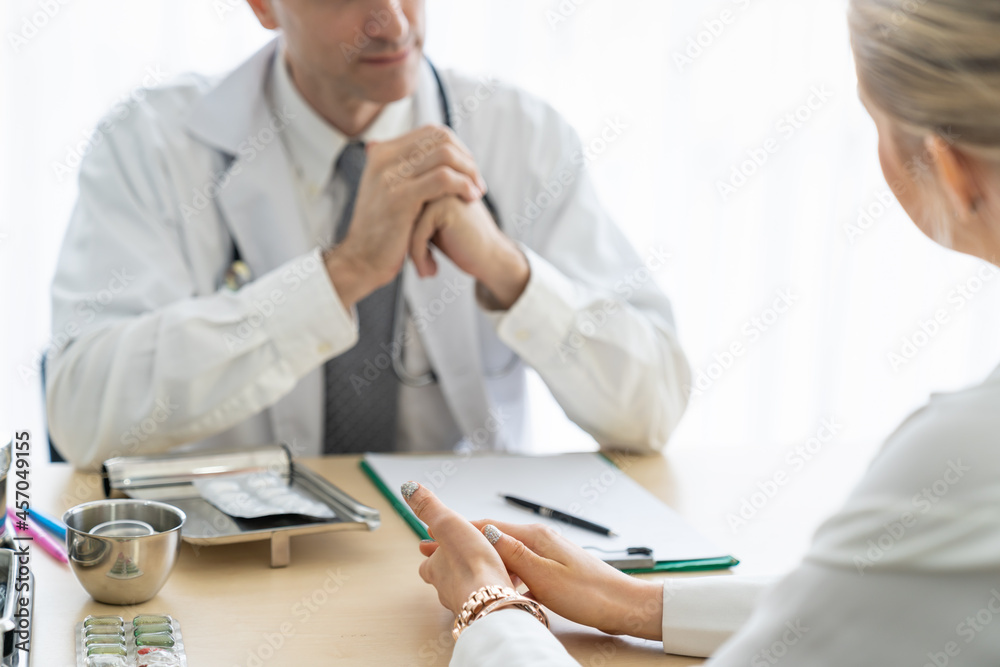 Doctor and female patient are discussing something in hospital office, Doctor talking to patient in medical office, Medicine and health care concept. Doctor and female patient are discussing something in hospital office, Doctor talking to patient in medical office, Medicine and health care concept.