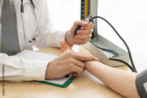 Doctor checking blood pressure of female patient in medical office, Medicine and health care concept. photo