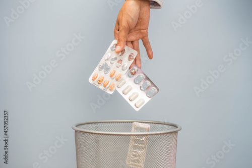 Wallpaper Mural Expired medicine. Woman's hand throws expired medicine in the trash. Drug quality deterioration. Store the medication for a long time. Torontodigital.ca