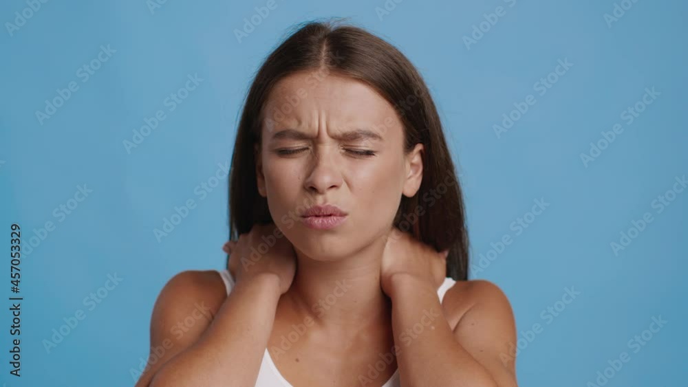 Woman Suffering From Nechache Massaging Aching Neck On Blue Background Woman Suffering From Nechache Massaging Aching Neck On Blue Background