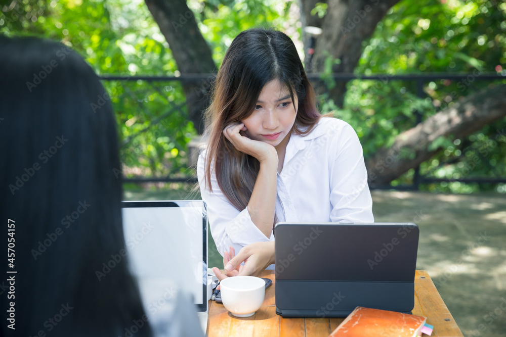 Two young business women sitting at table using laptop and smartphone in coffee shop cafe. Blogging Freelancers working. Woman using smartphone, business meeting. Two young business women sitting at table using laptop and smartphone in coffee shop cafe. Blogging Freelancers working. Woman using smartphone, business meeting.