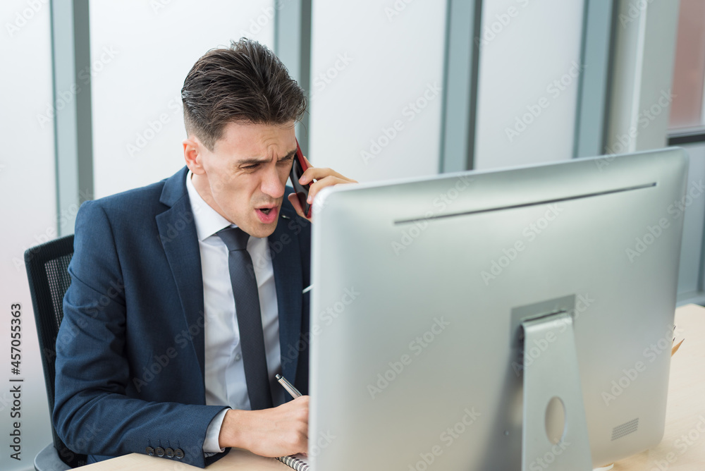 Bossy business man in suit outfit using smartphone to communicate to employee with serious and angry emotion in modern office room Bossy business man in suit outfit using smartphone to communicate to employee with serious and angry emotion in modern office room
