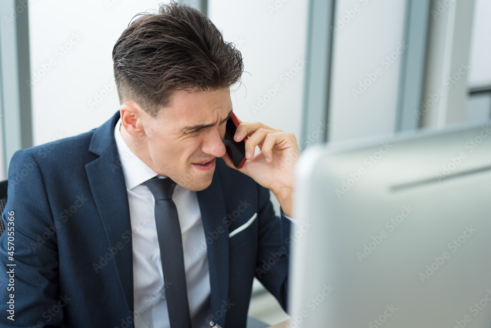 Bossy business man in suit outfit using smartphone to communicate to employee with serious and angry emotion in modern office room Bossy business man in suit outfit using smartphone to communicate to employee with serious and angry emotion in modern office room