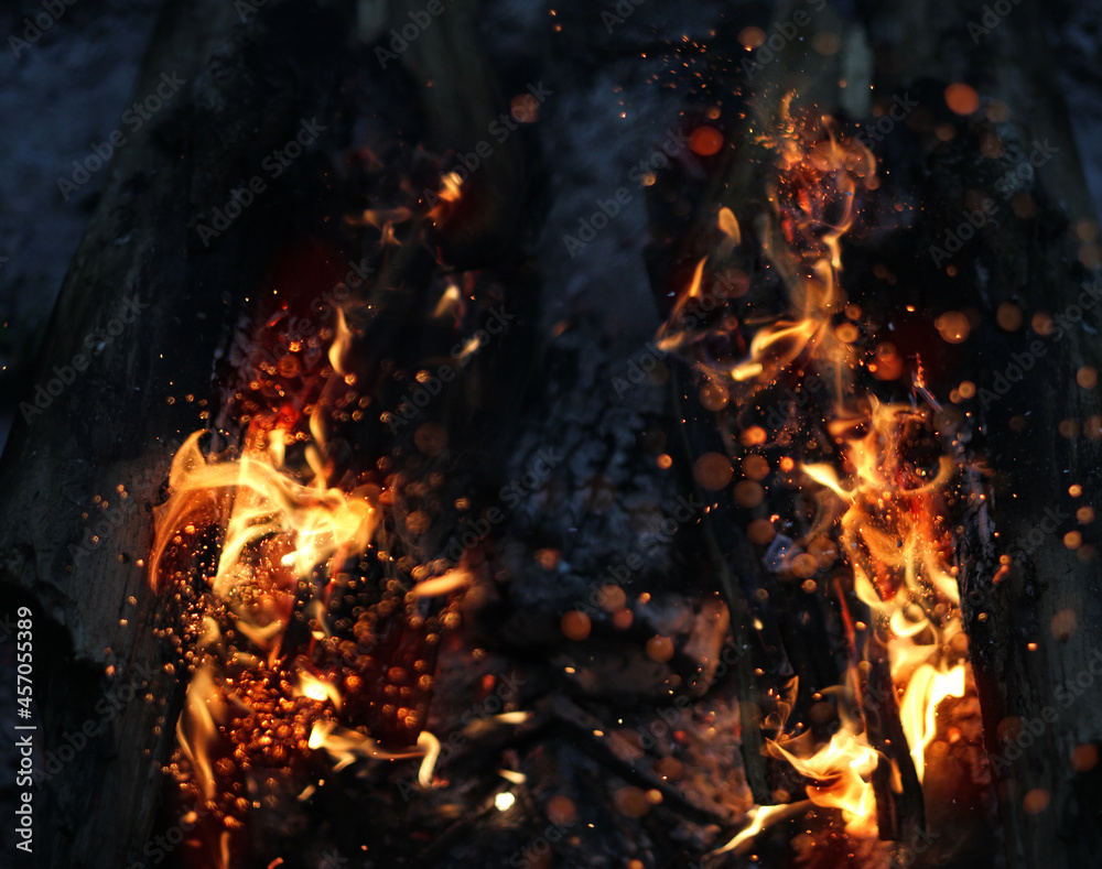 Abstract blurred dark background with open flame burns. flame of fire texture. Wood in fire outdoor and red coals in dark. mystery atmosphere scene Abstract blurred dark background with open flame burns. flame of fire texture. Wood in fire outdoor and red coals in dark. mystery atmosphere scene