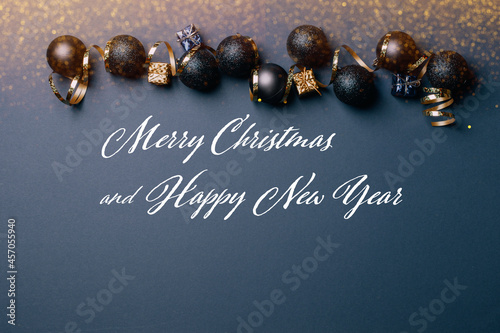 Beautiful golden silver decorations Christmas balls toys on a dark background Phrase Merry Christmas and Happy New Year