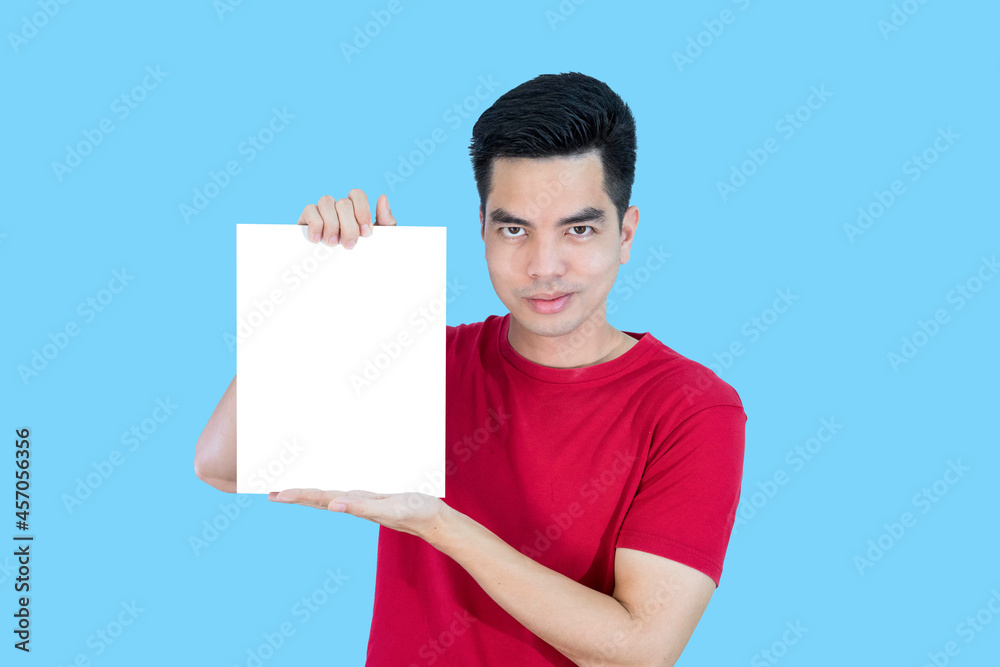 Portrait handsome young asian man wearing a red shirt holding a blank paper or billboard feeling happy isolated on blue background. Businessman concept. Portrait handsome young asian man wearing a red shirt holding a blank paper or billboard feeling happy isolated on blue background. Businessman concept.