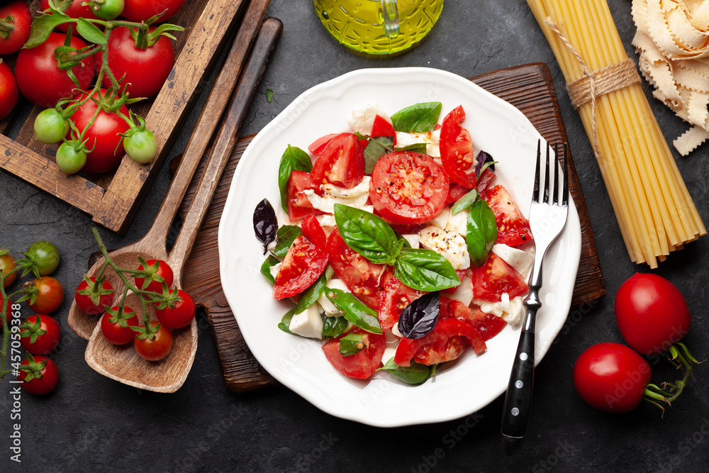 Caprese salad with fresh tomatoes, garden basil and mozzarella cheese Caprese salad with fresh tomatoes, garden basil and mozzarella cheese