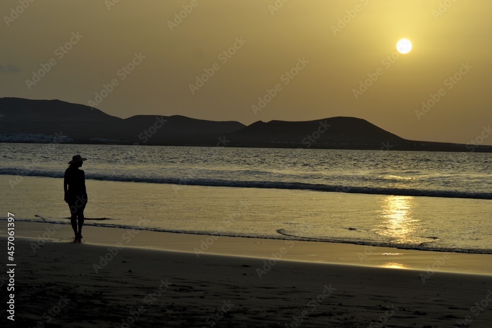 A beautiful sunset and a woman in a beach of Lanzarote