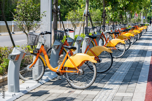 A public bicycle beside a street in a modern city