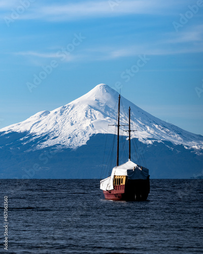 Vertical view of osorno volcano from puerto varas with ship in the foreground