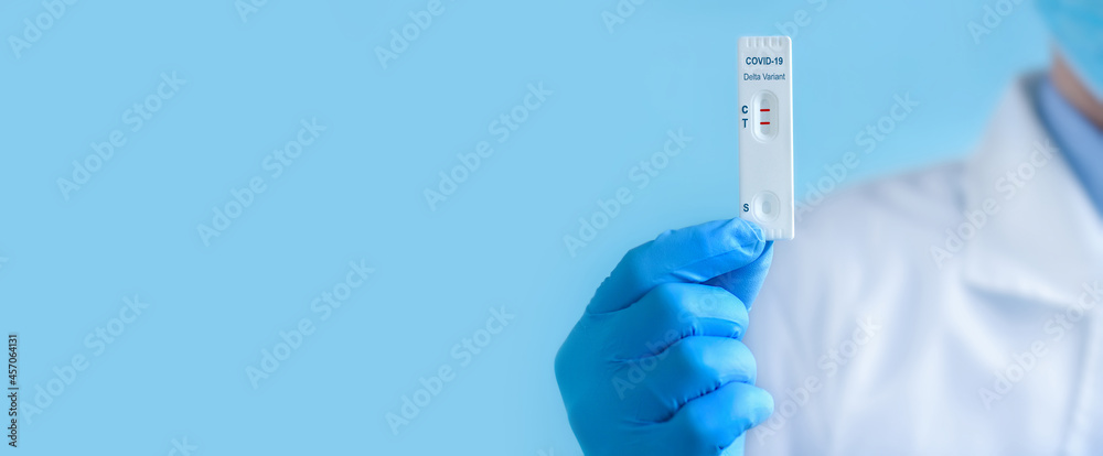 Doctor or nurse wearing a protective mask and gloves shows a rapid laboratory test for COVID-19 Delta Variant,to detect IgM and IgG antibodies to the new coronavirus. The test shows a positive result Doctor or nurse wearing a protective mask and gloves shows a rapid laboratory test for COVID-19 Delta Variant,to detect IgM and IgG antibodies to the new coronavirus. The test shows a positive result