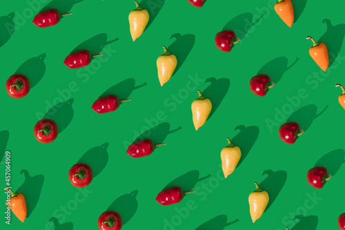 Peppers lay down on green background. Seamless pattern flaylat lay composition, minimal abstract spicy healthy eating concept