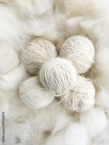 The balls of white natural wool are on a soft surface.