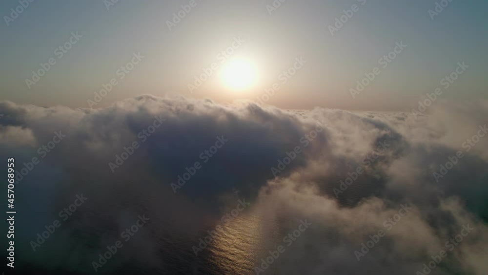 Fly through the clouds during sunrise. An epic shot of clouds in morning colors.