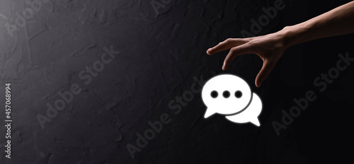 Businessman holding a message icon, bubble talk notification sign in his hands. Chat icon, sms icon, comments icon, speech bubbles