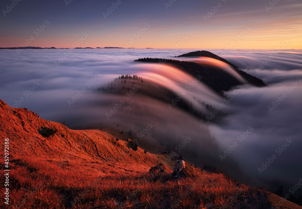Fototapeta premium Mountain landscape above clouds at sunset in Slovakia with forest and sun