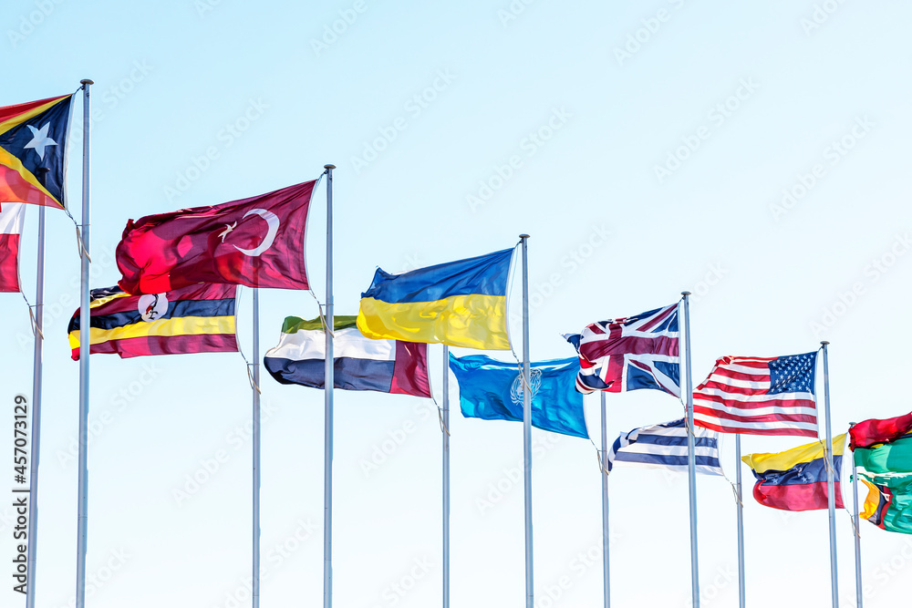 A row of different countries flags including Ukraine, US, UK on a sunny spring day in Canberra. Concept of multiculturalism A row of different countries flags including Ukraine, US, UK on a sunny spring day in Canberra. Concept of multiculturalism