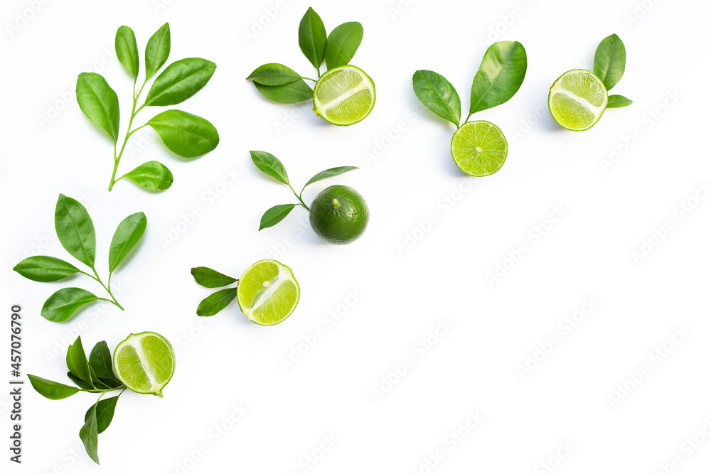 Obraz premium Fresh limes with green leaves on white background.