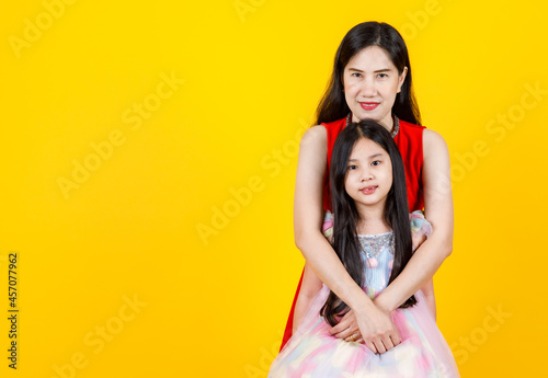 Lovely Asian mother cherish cute daughter as sweetheart by kindly hug from back with warm family love and empathy care of child girl, together smile for isolated portrait of happy female couple