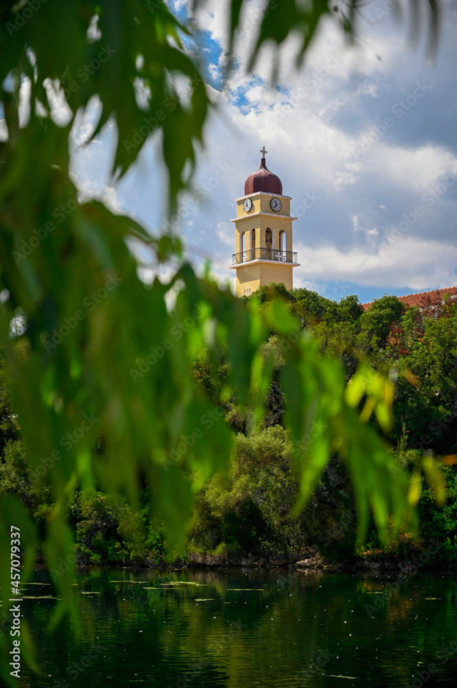 Belltower through the trees, on the edge of the lake