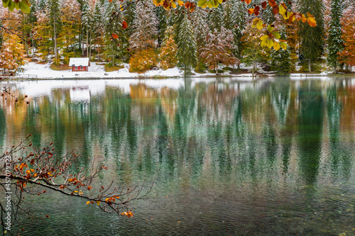 Between autumn and winter. Warm and cold reflections of snow on Lake Fusine.