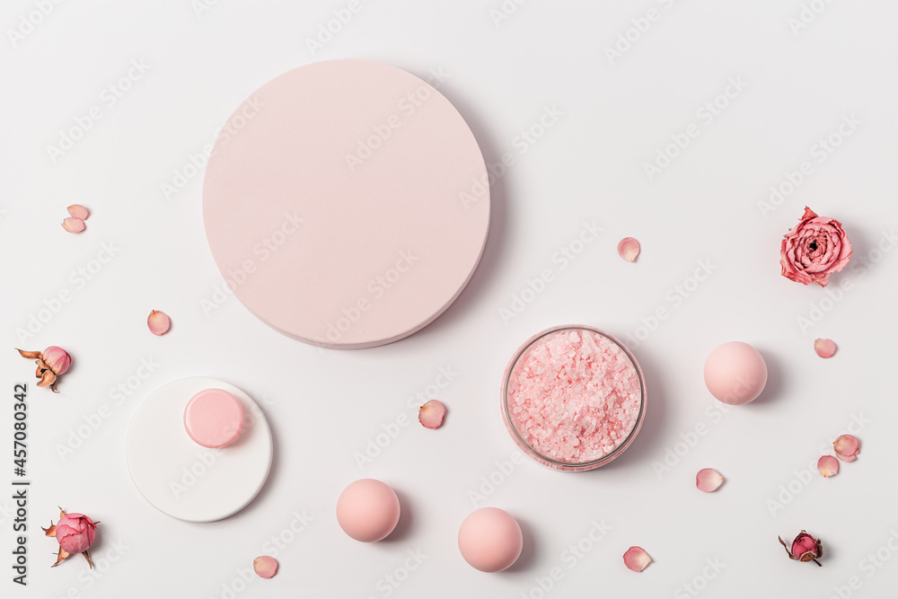 Rose scented sea salt in jar with small bottles shower gel, soap and rose flowers on round podium. Cosmetic product top view Rose scented sea salt in jar with small bottles shower gel, soap and rose flowers on round podium. Cosmetic product top view