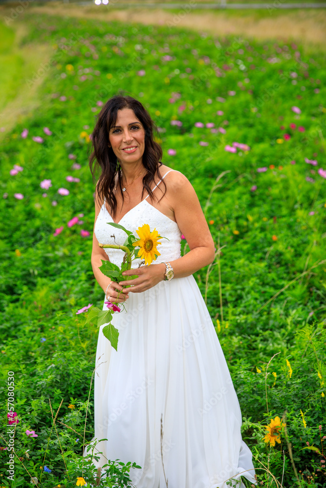 Junge hübsche Frau im Brautkleid in einer Blumenwiese Junge hübsche Frau im Brautkleid in einer Blumenwiese