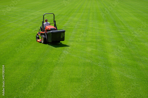 Mowing grass at the football stadium photo