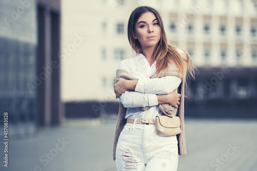 Young fashion woman in white shirt and ripped jeans