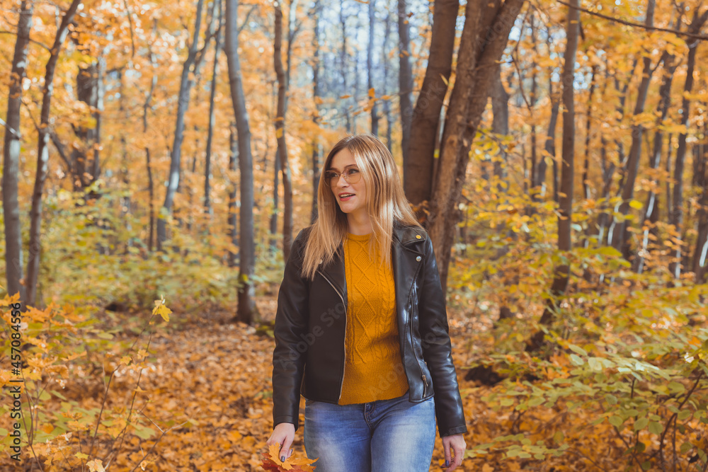 Girl holds fallen leaves and walks in autumn park. Seasonal concept. Girl holds fallen leaves and walks in autumn park. Seasonal concept.