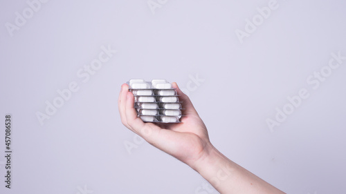 a man's hand holds a package of pills