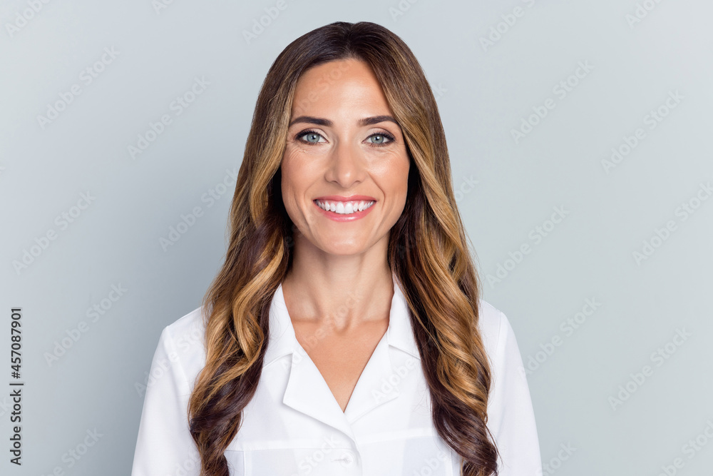 Photo of mature optimistic brown hairdo lady wear white nurse coat isolated on grey background Photo of mature optimistic brown hairdo lady wear white nurse coat isolated on grey background