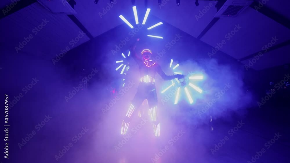 Laser led dance show. A group of dancers in glowing costumes dance. Laser show performance.